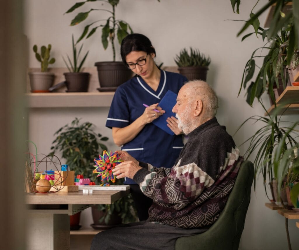 Elderly man engaging with a caregiver at RoseShire Festival event.